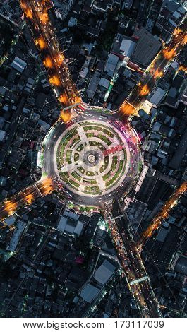 Road roundabout with car lots Wongwian Yai in BangkokThailand. street large beautiful downtown at night light. Aerial view Top view cityscape Rush hour traffic jam