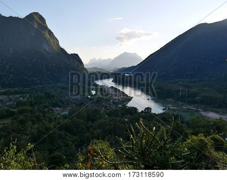 River and village muong ngoy Laos in a forest covered landscape with hills and mountains