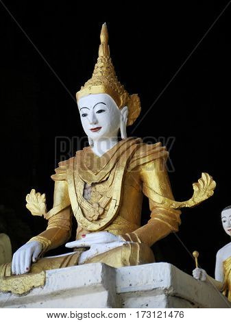 white golden buddha statue on black background