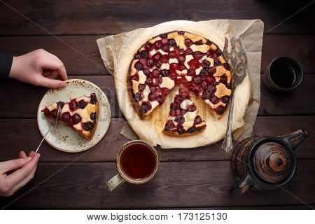 Homemade cherry pie with tea cup on wooden table. Lay flat. Top view
