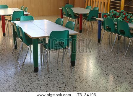 Inside The Classroom Of A School With Green Chairs And Small Tab