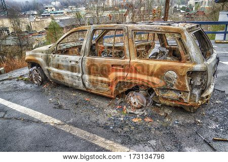 GATLINBURG TENNESSEE/USA - DECEMBER 14 2016: A burned-out car waits for clean-up crews in the aftermath of a massive forest fire that destroyed part of Gatlinburg TN in late 2016.