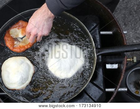 Hands Of Cook Frying Large Frybread.. In A Pan Of Hot Oil