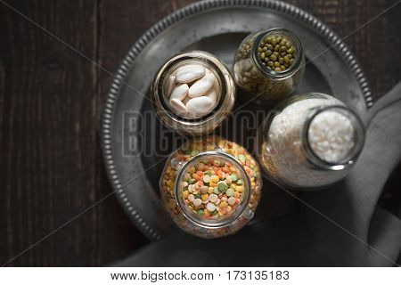 White beans, green beans, lentils and rice in cans on a tin plate horizontal