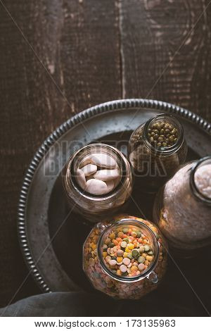 Beans, lentils, rice, bottled on a tin plate vertical