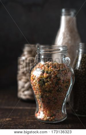 Lentils, rice, large white beans in glass jars vertical