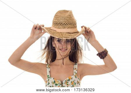 young lovely girl in sarafan with floral pattern and straw hat looking and smiling on camera isolated on white