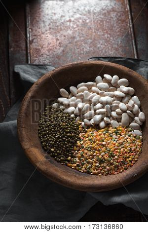 Placer green and white beans in a wooden bowl vertical