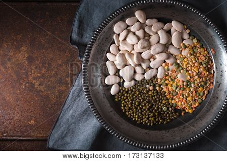 Placer green and white beans, lentils in a wooden bowl and a napkin horizontal