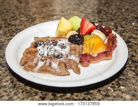 american breakfast with meat and fresh fruits and cream on a plate
