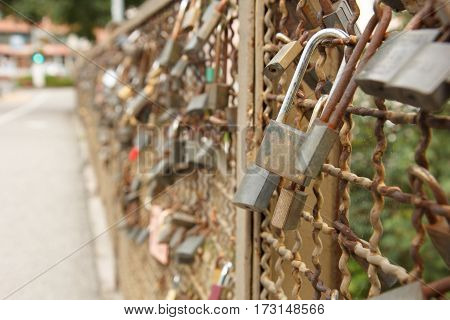 Love locks locked on the fence of the bridge in Bruneck Italy