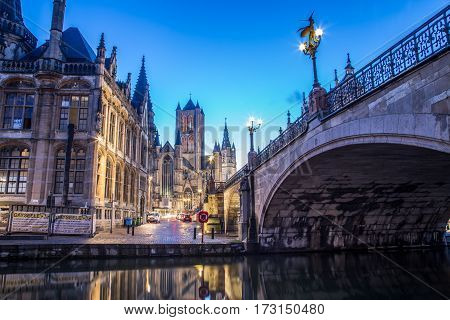 GHENT BELGIUM - 19TH FEB 2016: A view towards Saint Nicholas' Church in Ghent City Center at dusk in the morning. Reflections can be seen in the river Leie