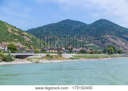 KREMS AUSTRIA - 28TH AUGUST 2015: Buildings along the waterfront in Krems. Wineries and hills and people can be seen.