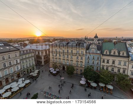 KRAKOW POLAND - 15TH OCTOBER 2016: Buildings and restaurants on Rynek Glowny (Main Square) in Krakow at sunset. People can be seen.