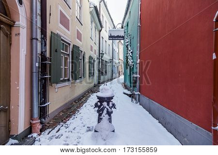 RIGA LATVIA - 3RD JAN 2017: A view along Torna Iela in Riga during the day showing the outside of shops restaurants and snow.