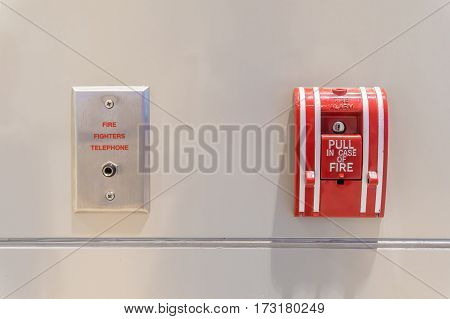 Push button switch fire alarm box on cement wall for warning and security system with fire fighters telephone port