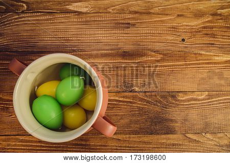 colored Eggs in a jar on wooden bacground