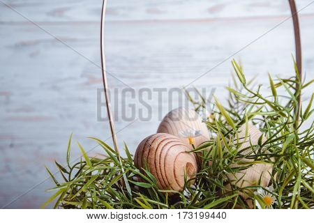 easter eggs in basket on white wooden background