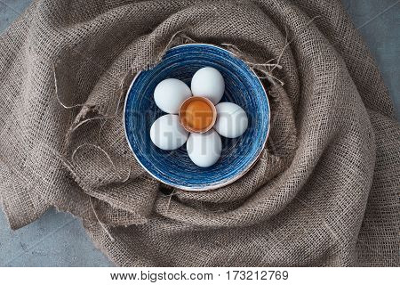 Ecological natural fresh eggs collected in the plate for cooking on the fabric.