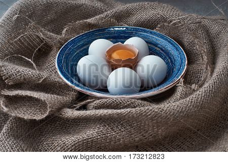Ecological natural fresh eggs collected in the plate for cooking on the fabric.