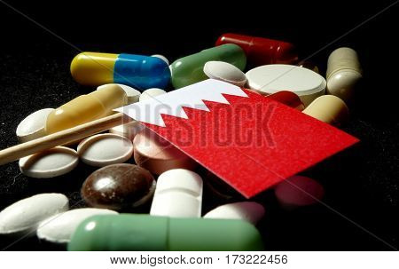 Bahraini Flag With Lot Of Medical Pills Isolated On Black Background