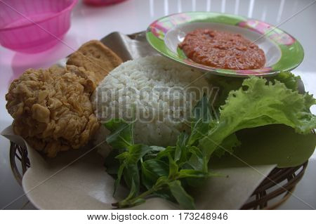 indonesia food this name is LALAPAN material is tofu chicken rice and sauce made with shrimp paste