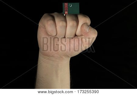 Man Hand Fist With Turkmenistani Flag Isolated On Black Background