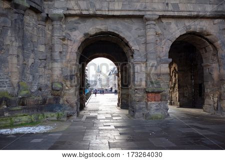 TrierGermany- January 03 2017: Porta Nigra (Black Gate) - the biggest and most well-preserved ancient gates worldwide.Not far walking tourists