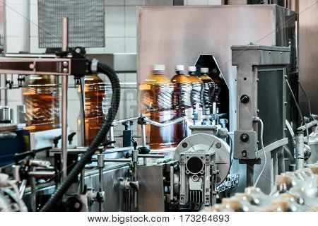 Plastic bottles filled with beer on the conveyor of the filling machine. Phase control on the absence of extraneous inclusions.