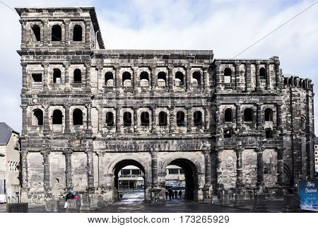 TrierGermany- January 03 2017: Porta Nigra (Black Gate) - the biggest and most well-preserved ancient gates worldwide.Not far walking tourists