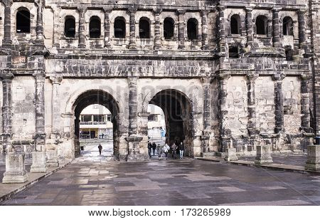 TrierGermany- January 03 2017: Porta Nigra (Black Gate) - the biggest and most well-preserved ancient gates worldwide.Not far walking tourists