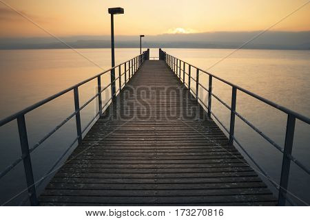 Wooden Footbridge into the lake of constance during a golgen sunset, germany