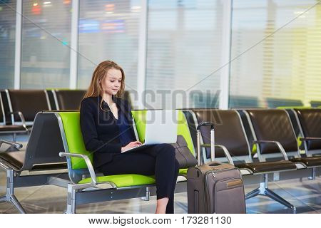 Woman In International Airport Terminal, Working On Her Laptop