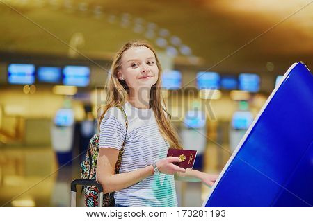 Tourist Girl With Backpack And Carry On Luggage In International Airport, Doing Self Check-in
