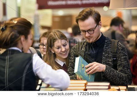 VILNIUS - FEBRUARY 25: Many people choose books at the indoor book market on February 25 2017 in Vilnius Lithuania. Vilnius is the capital of Lithuania and its largest city.