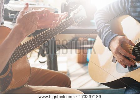 Masterclass learning to play the guitar outdoors. Musical education.