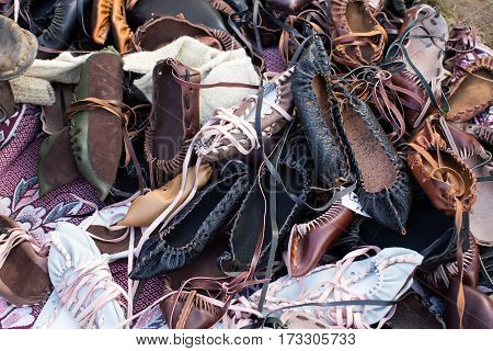 Pile of traditional Romanian leather peasant sandals.