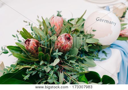 Wedding Guest Table, Decorated With Protea Bouquet And Settings And Candlesticks And Globe
