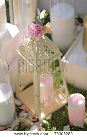 Beautifully Composition Of Candles And Red Flowers On Grass