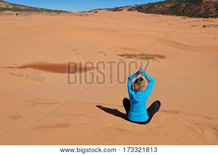 Woman meditating in desert. Coral Pink Sand Dunes State Park. Cedar City. Kanab. Utah. United States.