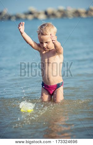 Little boy with snorkel by the sea. Cute little kid wearing mask and flippers for diving at sand tropical beach. Ocean coast.