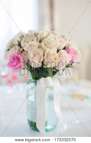 Beautiful wedding bouquet of delicate beige roses stands on the table