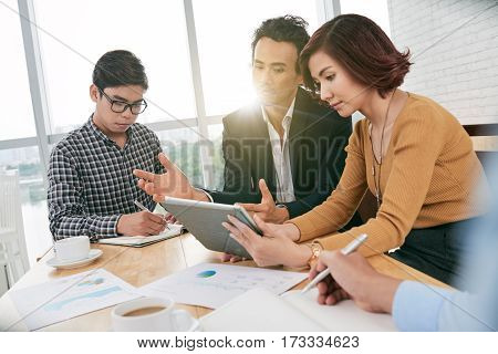 Business people reading information on tablet computer