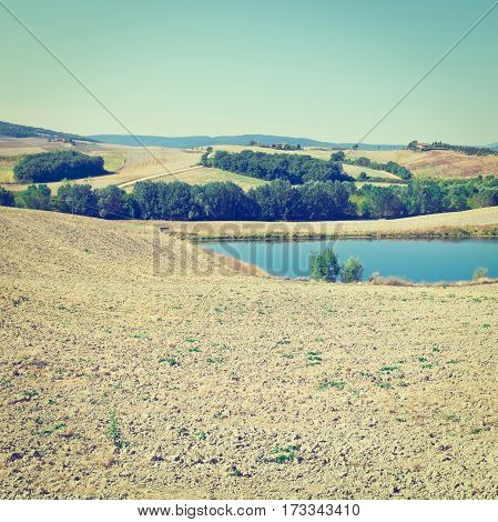 Tuscany Landscape with Pond Surrounded by Plowed Fields in the Autumn Italy Instagram Effect