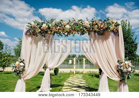 Beautiful wedding archway. Arch decorated with biege cloth and flowers
