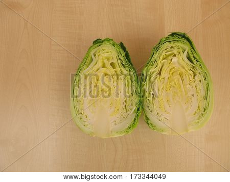 Cut open head of cone cabbage on wooden board
