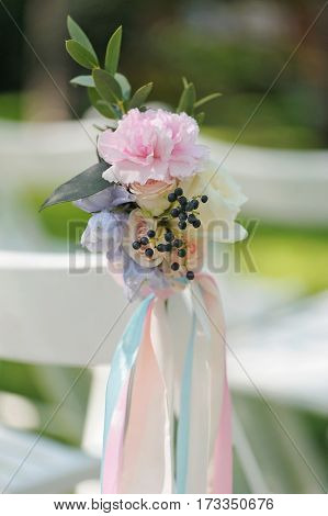 Pink peon and roses buds in tenderless boutonniere, with biege and pink ribbons, closeup