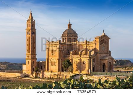 Gozo Malta - The Basilica of the National Shrine of the Blessed Ta' Pinu at sunset with clear blue sky on a summer day