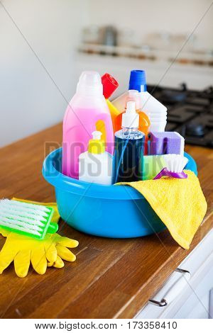 Basket With Cleaning Items On Blurry Background White Citchen. Cleaning Concept.