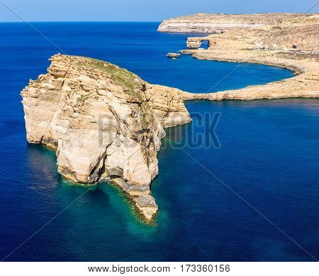 Gozo Malta - The Fungus Rock and the Azure Window at Dwejra bay on a beautiful summer day with clear blue sky sea water